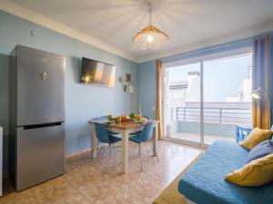 Il comprend une cuisine et une salle à manger avec une table et un réfrigérateur. dans l'établissement Casita Canaria First Line Terrace y Seaside View, à Las Palmas de Gran Canaria