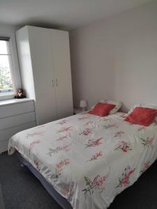 1 dormitorio con cama blanca y almohadas rojas en Appartement 3 pièces Paris sud, en Ivry-sur-Seine