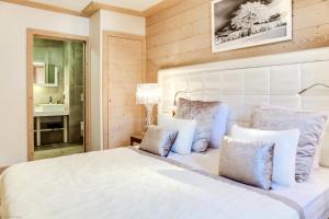 a bedroom with a white bed with blue pillows at Résidence Carre Blanc - 3 Pièces pour 4 Personnes 424 in Courchevel
