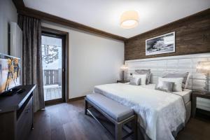 a bedroom with a bed and a desk and a window at Résidence Carre Blanc - 3 Pièces pour 6 Personnes 464 in Courchevel