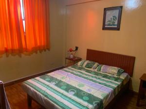 a bedroom with a bed and orange curtains at Hostal Residencial La Esmeralda in Lima