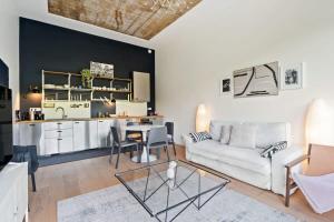 a living room with a white couch and a table at Designed Apt w Pool in Dommeldange in Luxembourg