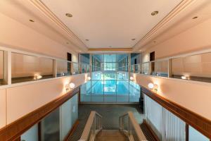 an empty corridor in a building with a pool at Elegant 1BR Apt, Balcony, Pool, Central Location in Luxembourg