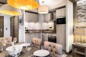 een keuken met een eettafel en stoelen bij Résidence Carre Blanc - 3 Pièces pour 4 Personnes 504 in Courchevel