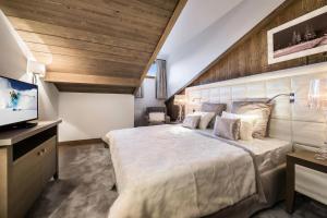 een slaapkamer met een groot bed en een flatscreen-tv bij Résidence Carre Blanc - 3 Pièces pour 4 Personnes 504 in Courchevel