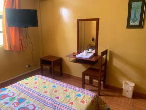 a bedroom with a bed and a desk with a mirror at Hostal Residencial La Esmeralda in Lima