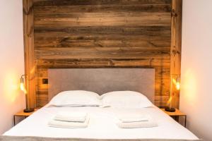een slaapkamer met een houten muur en een bed met 2 handdoeken bij Résidence Androsace Du Lyret - 2 Pièces pour 2 Personnes 564 in Chamonix-Mont-Blanc