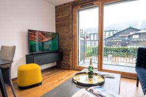 een woonkamer met een groot raam en een televisie bij Résidence Androsace Du Lyret - 2 Pièces pour 2 Personnes 564 in Chamonix-Mont-Blanc
