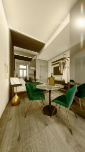 sala de estar con sillas verdes y mesa en 5GreenLuxurieRooms, en Turín