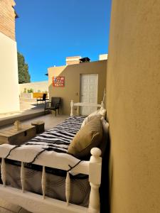 a bed sitting on a porch with at Casa Amonite Hostel Boutique in Puerto Madryn