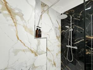 y baño con ducha de mármol blanco y negro. en La Dolce Luna: a pochi passi dal centro di Bari, en Bari