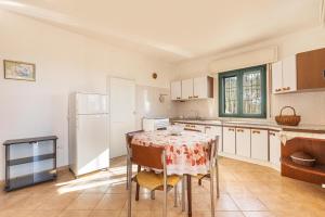 een keuken met een tafel met stoelen en een koelkast bij Salentoandmore -Villetta Jole in Morciano di Leuca