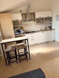 a kitchen with white cabinets and a table and chairs at Sweet Home in Lissone