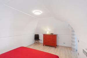 um quarto com uma cómoda vermelha e uma cadeira em [Amalfi Coast]Elegant house in Penisola Sorrentina em Vico Equense