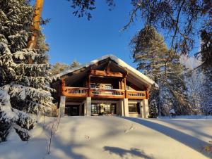 a log cabin in the snow with snow covered trees at Kolin Runo in Yläkoli