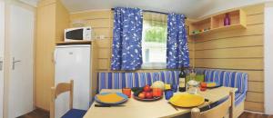 eine Küche mit einem Tisch und einer Obstschale darauf in der Unterkunft Mobilhome 4 étoiles - Parc aquatique - eeia0f in Le Bois-Plage-en-Ré