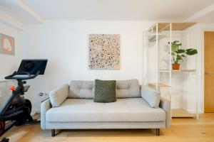 a living room with a white couch and a bike at Pass the Keys Modern Garden Flat - Steps from HI Upper Street in London