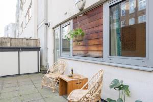 un patio con 2 sillas, una mesa y una ventana en Pass the Keys Modern Garden Flat - Steps from HI Upper Street en Londres
