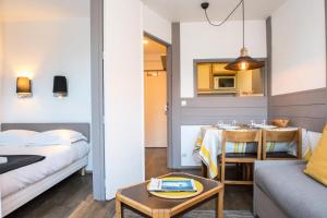 une chambre d'hôtel avec un lit et une salle à manger dans l'établissement Résidence Chamois Blanc - 2 Pièces pour 4 Personnes 694, à Chamonix-Mont-Blanc