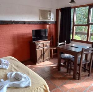 a room with a desk and a table with a television at San Remo Villa Corral Apart in Carilo