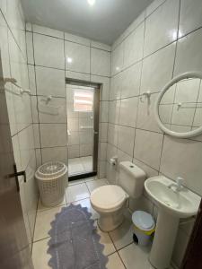 bagno con servizi igienici, lavandino e specchio di Casa Aventura a Passo de Torres