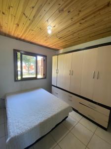 a bedroom with a bed and a wooden ceiling at Casa Aventura in Passo de Torres