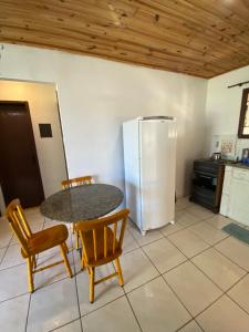 a kitchen with a table and chairs and a refrigerator at Casa Aventura in Passo de Torres
