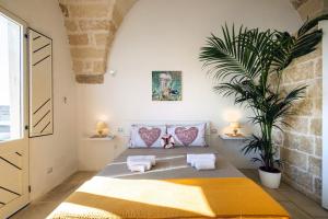 - une chambre avec un lit et une plante dans l'établissement Charme Palace Salento, à Salice Salentino