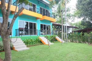 a blue building with stairs in front of a yard at Samui Poshtel in Chaweng