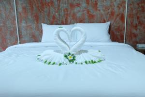two swans made out of flowers on a bed at Samui Poshtel in Chaweng