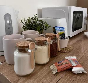 un comptoir avec des bocaux de nourriture et un micro-ondes dans l'établissement Private guest house - Double bedroom, en-suite and workspace with private entrance, first floor with no lift and no full kitchen, à Leicester