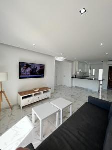 uma sala de estar com um sofá e uma televisão na parede em F&M - Quinta do Torrejão Alporchinhos Algarve em Porches