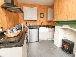 a kitchen with wooden walls and a stove at Coach House in Denbigh