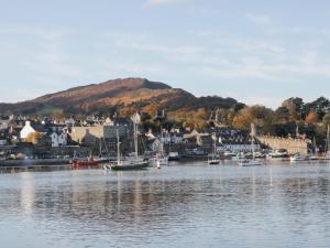 a body of water with boats in a town with a mountain at Coach House in Denbigh