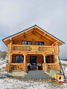 une cabane en rondins dans la neige dans l'établissement BearHouse Chalet, à Poiana Mărului