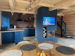a kitchen with a table and a tv on a wall at BearHouse Chalet in Poiana Mărului