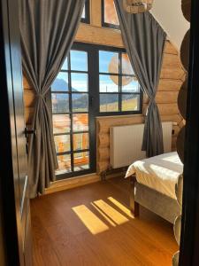 1 dormitorio con cama y ventana grande en BearHouse Chalet en Poiana Mărului