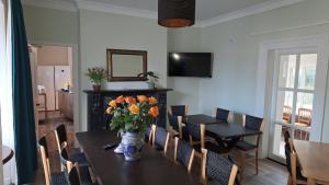 a dining room with a table with a vase of flowers on it at The Monkey Puzzle in Bunclody