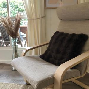 una silla de madera con una manta delante de una ventana en Chalet 2Relax en Zutendaal