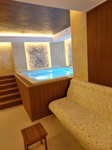 a jacuzzi tub in a room with a bench at Binis in Zlatibor