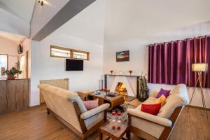 a living room with two couches and a fireplace at StayVista at The West Wind in Ooty