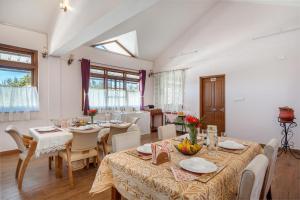 a dining room with tables and chairs in a room at StayVista at The West Wind in Ooty