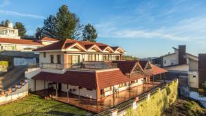 a house with a metal roof on a deck at StayVista at The West Wind in Ooty