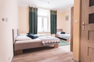 a bedroom with two beds and a window at Mazurek - pokoje do wynajęcia in Duszniki Zdrój