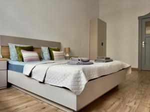 1 dormitorio con 1 cama blanca grande con almohadas en Sophie Apartment, en Poznan