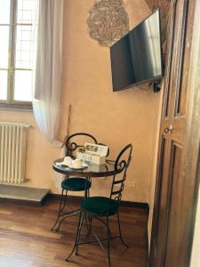 a table with two chairs and a television on a wall at Luxury Corte dei Nobili in Lucca