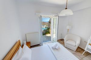 a room with a bed and a table and a chair at Villa la vue in Ano Syros