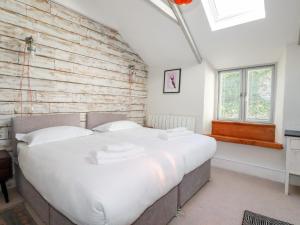 ニューキーにあるPilgrim Cottageのレンガの壁の客室で、大型ベッド1台を利用できます。