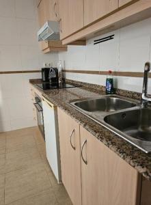 een keuken met een wastafel en een aanrecht bij habitacion en piso compartido cerca de playa in Xilxes