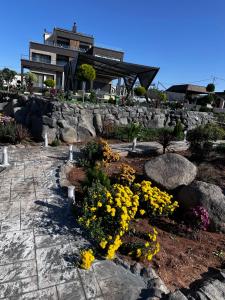 Al MashāriqahKinda vip的一座花园,在房子前面有黄色的花朵